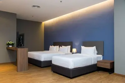 two beds in a hotel room with blue walls at Imperial Suites @Bangsar by Plush in Kuala Lumpur