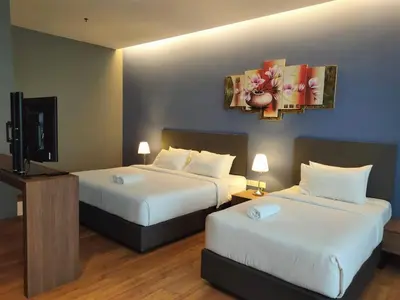 a hotel room with two beds and a flat screen tv at Imperial Suites @Bangsar by Plush in Kuala Lumpur