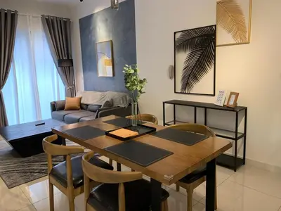 a living room with a wooden table and chairs at Continew by Plush Services in Kuala Lumpur