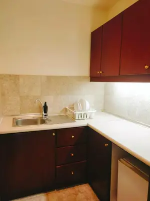 a kitchen with brown cabinets and a sink at Suites at TimesSquare by Plush in Kuala Lumpur
