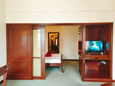 a hotel room with a television and a bedroom at Suites at TimesSquare by Plush in Kuala Lumpur