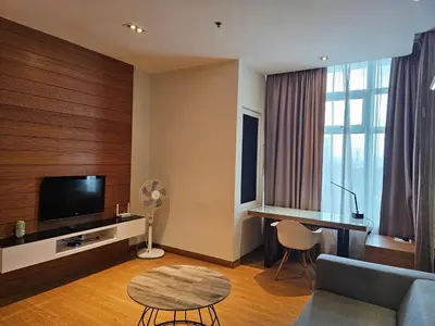 a living room with a couch and a tv and a table at Deluxe Family, Dua Sentral in Kuala Lumpur