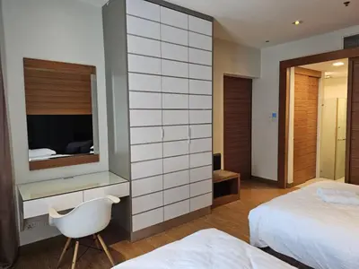 a bedroom with a bed and a mirror and a chair at Deluxe Family, Dua Sentral in Kuala Lumpur