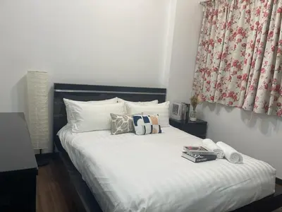 a bedroom with a white bed with pillows and a window at Villa Wangsamas By A.Golkar in Kuala Lumpur