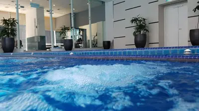 a swimming pool with blue water in a building at Binjai 8 by Plush in Kuala Lumpur