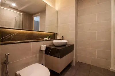 a bathroom with a white toilet and a sink at Nadi Bangsar by Plush in Kuala Lumpur