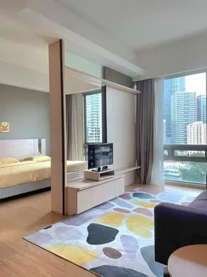 a living room with a bed and a television at Kids Friendly Kuala Lumpur Apartment in Kuala Lumpur
