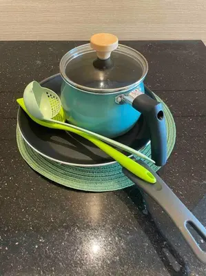 a pot and a pair of tongs sitting on a plate at Kids Friendly Kuala Lumpur Apartment in Kuala Lumpur