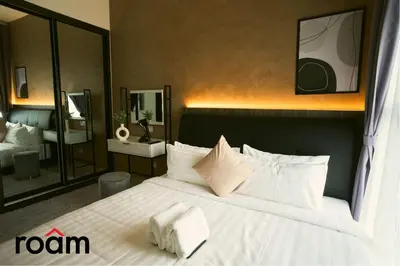 a bedroom with a large bed with white sheets and pillows at Trion Kuala Lumpur by Roam in Kuala Lumpur