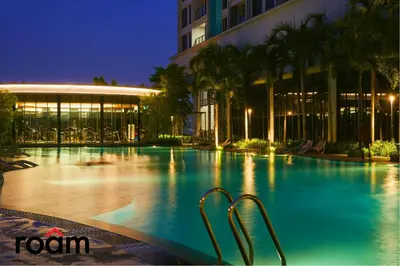 a swimming pool in front of a building at night at Trion Kuala Lumpur by Roam in Kuala Lumpur