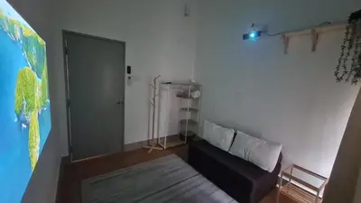 a living room with a black couch in a room at Mimi Cozy Homestay, 3R3B KLCC View with PLAYSTATION 4, NETFLIX, WiFi 6, Pool Table, Home Cinema in Kuala Lumpur