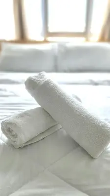 two towels sitting on top of a bed at Mimi Cozy Homestay, 3R3B KLCC View with PLAYSTATION 4, NETFLIX, WiFi 6, Pool Table, Home Cinema in Kuala Lumpur