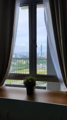a window with a potted plant sitting on a window sill at Mimi Cozy Homestay, 3R3B KLCC View with PLAYSTATION 4, NETFLIX, WiFi 6, Pool Table, Home Cinema in Kuala Lumpur