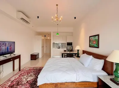 a bedroom with a large white bed and a living room at KLCC View with Balcony @ Chambers, KL Near LRT PWTC & Sunway Putra Mall in Kuala Lumpur