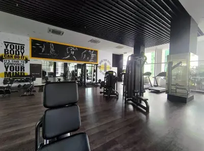 a gym with exercise equipment and chairs in a room at Quill Residences KL By Minos Home in Kuala Lumpur