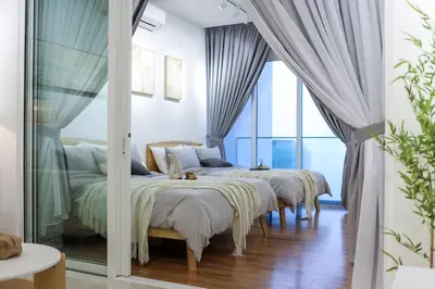 a bedroom with four beds and a large window at Quill Residences KL By Minos Home in Kuala Lumpur
