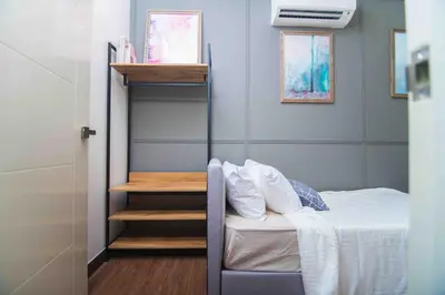 a small bedroom with a bed and a staircase at Arte Mont Kiara in Kuala Lumpur