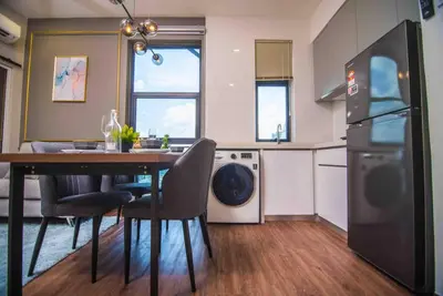 a kitchen with a table with chairs and a refrigerator at Arte Mont Kiara in Kuala Lumpur
