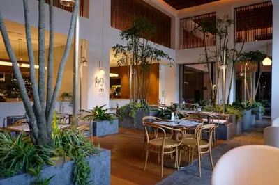 a restaurant with a table and chairs and plants at The Establishment Bangsar KL by Lynhomes in Kuala Lumpur