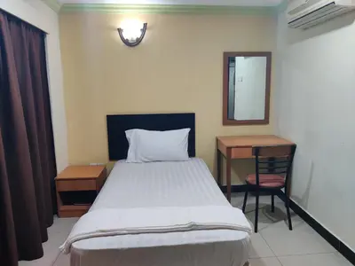 a bedroom with a bed and a desk and a mirror at Hotel WKL in Kuala Lumpur