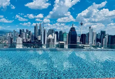 a swimming pool with a view of a city skyline at Spacious Home for 6pax - Regalia Suite - Infinity Pool with KL City View - Free Wi-Fi & Parking in Kuala Lumpur