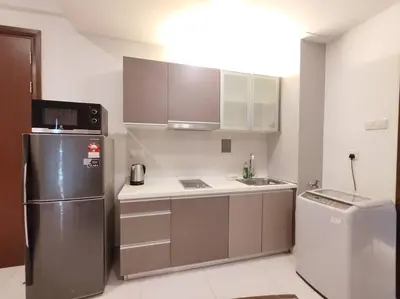 a small kitchen with a refrigerator and a sink at Spacious Home for 6pax - Regalia Suite - Infinity Pool with KL City View - Free Wi-Fi & Parking in Kuala Lumpur