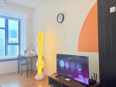 a living room with a tv and a table with a clock at KLCC VIEW,5 mins to KL TOWER in Kuala Lumpur