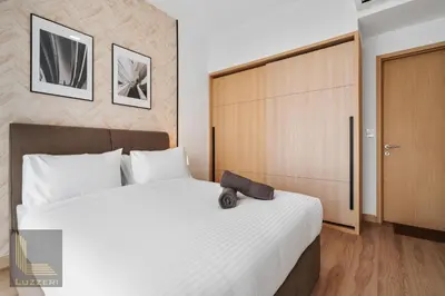 a bedroom with a large white bed and a wooden door at Colony Chow Kit Guesthouse in Kuala Lumpur