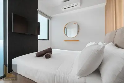 a bedroom with a white bed and a mirror at Colony Chow Kit Guesthouse in Kuala Lumpur