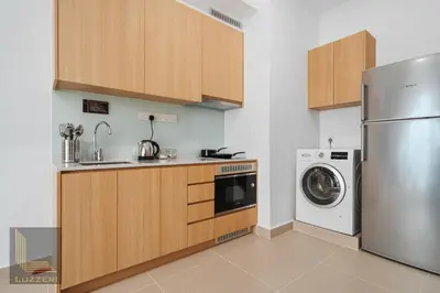 a kitchen with a refrigerator and a washer and dryer at Colony Chow Kit Guesthouse in Kuala Lumpur
