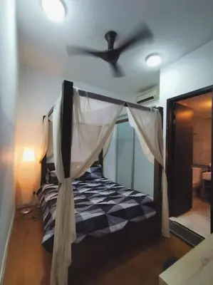 a bedroom with a bed with a ceiling fan at Studio with an amazing view. 10 min to KLCC in Kuala Lumpur