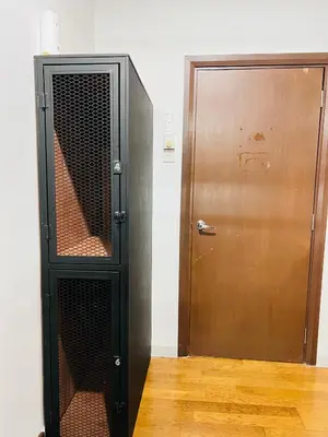a black cabinet next to a wooden door at Regalia Spritz Empire Hostel in Kuala Lumpur