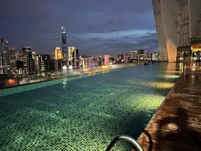 a swimming pool with a city skyline at night at Regalia Spritz Empire Hostel in Kuala Lumpur