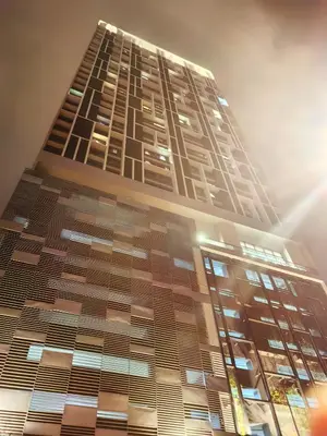 a tall building with the sun behind it at Chambers Residence KLCC By Purple Orchid in Kuala Lumpur
