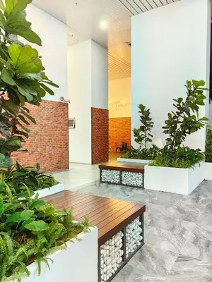 a lobby with plants and a wooden bench at Chambers Residence KLCC By Purple Orchid in Kuala Lumpur