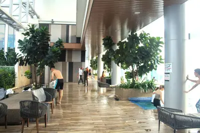 a lobby of a building with people and plants at The Luxe Suites KLCC by Cozy Stay in Kuala Lumpur
