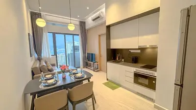 a kitchen and living room with a table and chairs at The Luxe Suites KLCC by Cozy Stay in Kuala Lumpur