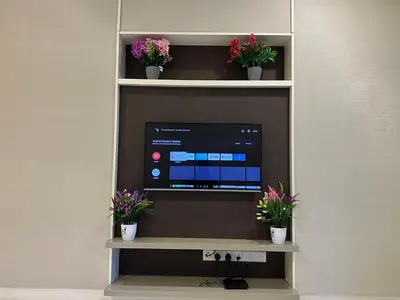 a tv sitting on a shelf with potted plants at Platinum suites by BLUE SKY in Kuala Lumpur