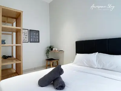 a bedroom with a white bed with a black headboard at Trion @ KL By Awesomestay in Kuala Lumpur