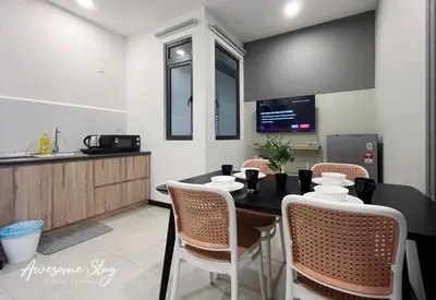 a kitchen and dining room with a table and chairs at Neu Suites By Awesomestay in Kuala Lumpur