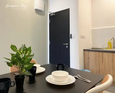 a black table with white plates and a plant on it at Neu Suites By Awesomestay in Kuala Lumpur