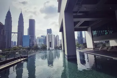 a swimming pool in the middle of a city with tall buildings at King Studio Suite Legasi Kampung Bharu view KLCC in Kuala Lumpur
