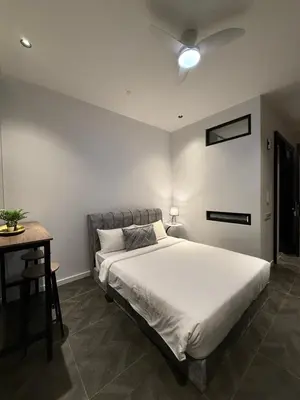 a bedroom with a large bed and a table at Scarletz Suites KLCC Kuala Lumpur by OKIDOKI Homes in Kuala Lumpur