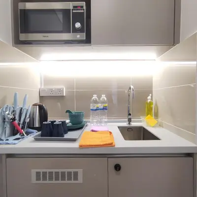 a kitchen counter with a sink and a microwave at TRION Studio 4 PAX Teneleven in Kuala Lumpur