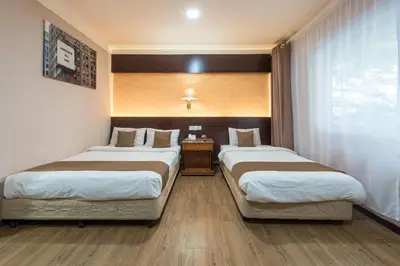a hotel room with two beds and a window at Grand Orchard Hotel Premier in Kuala Lumpur