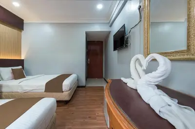 a hotel room with two beds with swan towels at Grand Orchard Hotel Premier in Kuala Lumpur