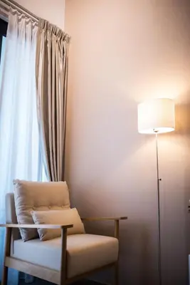 a room with a chair and a lamp and a window at KLCC EST Bangsar By PSM in Kuala Lumpur