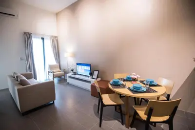 a living room with a table and chairs and a television at KLCC EST Bangsar By PSM in Kuala Lumpur