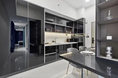 a kitchen with black cabinets and a table and chairs at Novo Kuala Lumpur in Kuala Lumpur