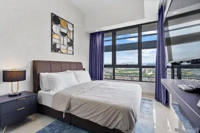 a bedroom with a bed and a desk and a window at Novo Kuala Lumpur in Kuala Lumpur